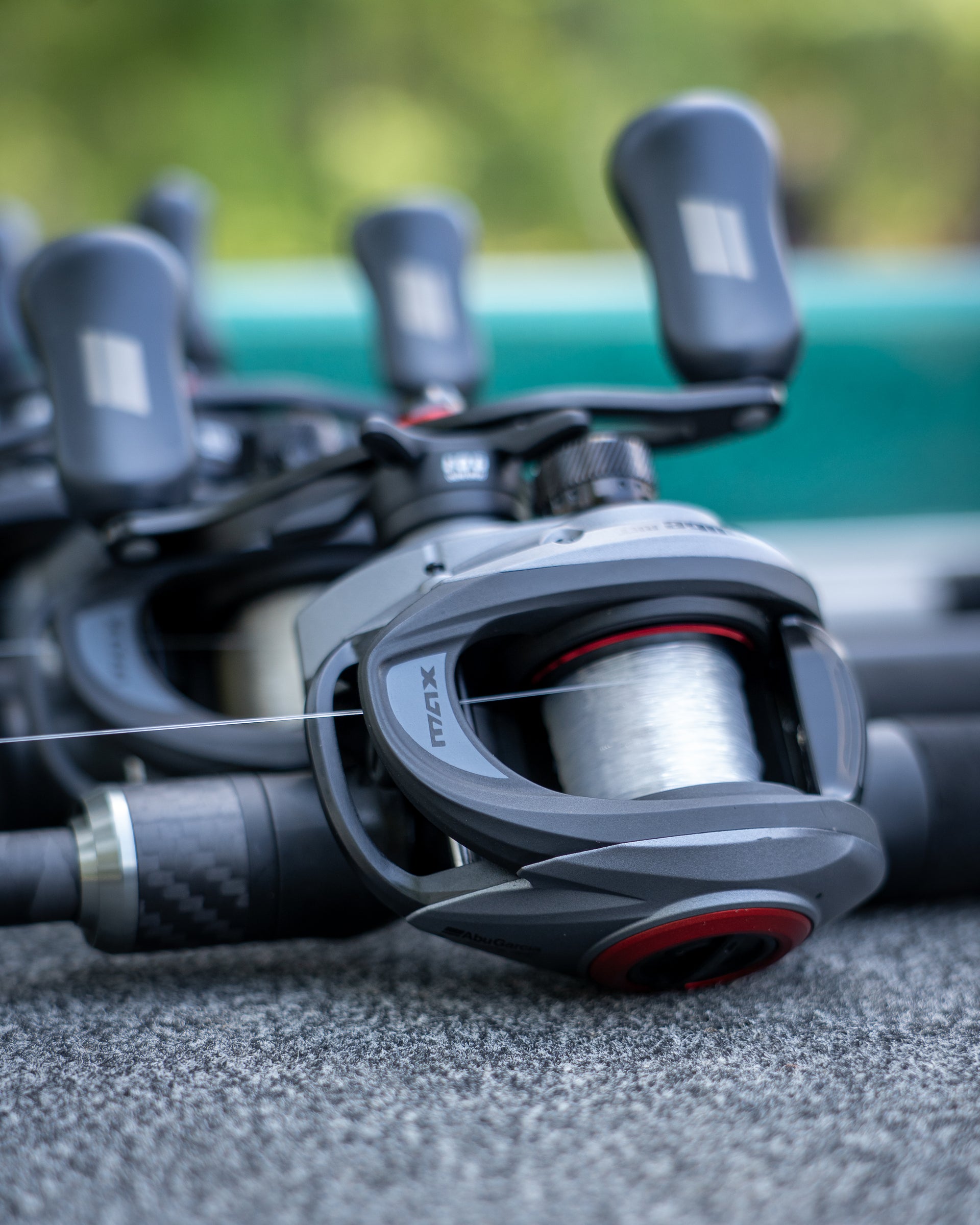 Close-up of a Abu Garcia Max Elite LP Reel on concrete with a blurred background. 