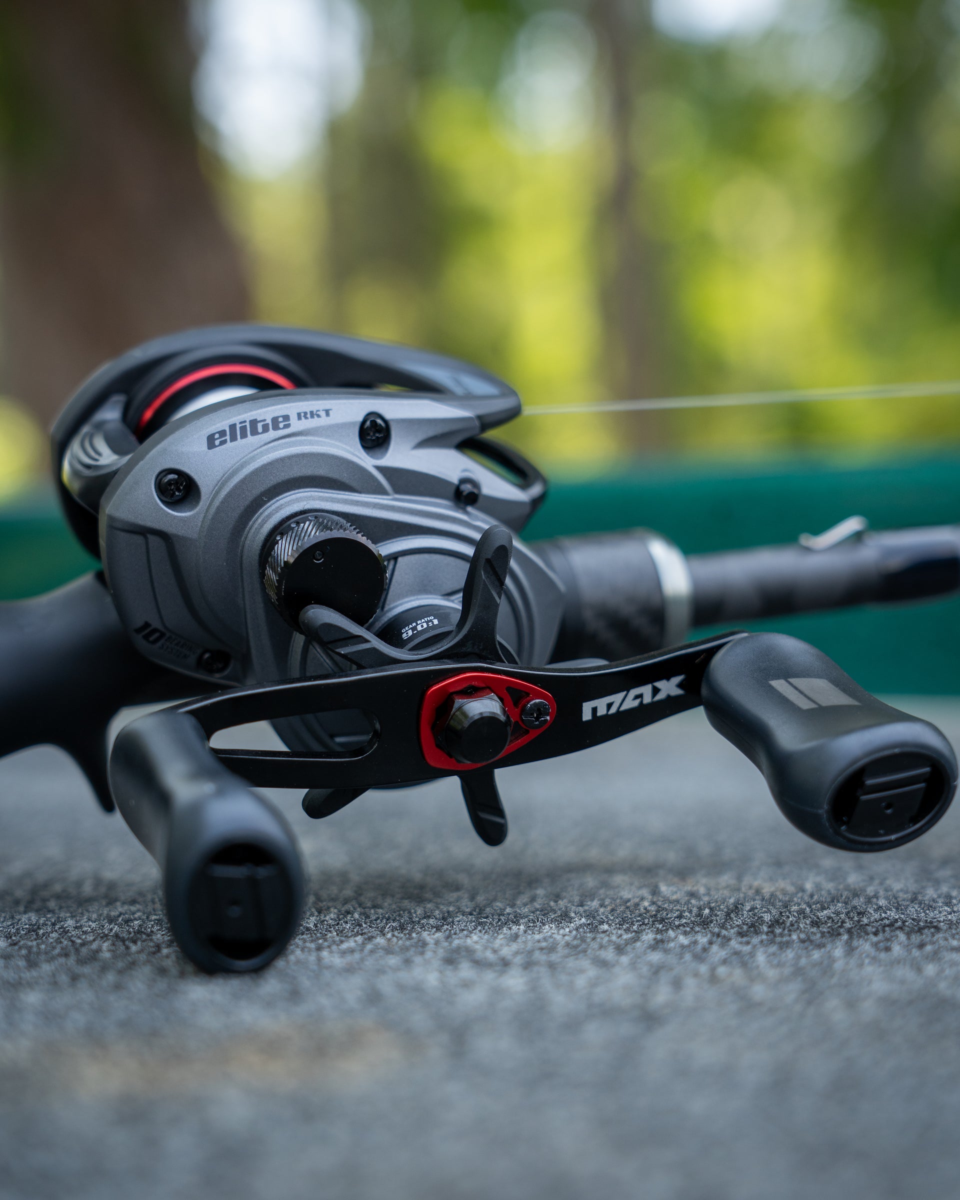 Close-up of a Abu Garcia Max Elite LP Reel on concrete with a blurred background. 